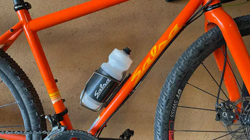 Bicycle water bottle cage adaptor shown installed, bottle cage repositioned 52mm down.